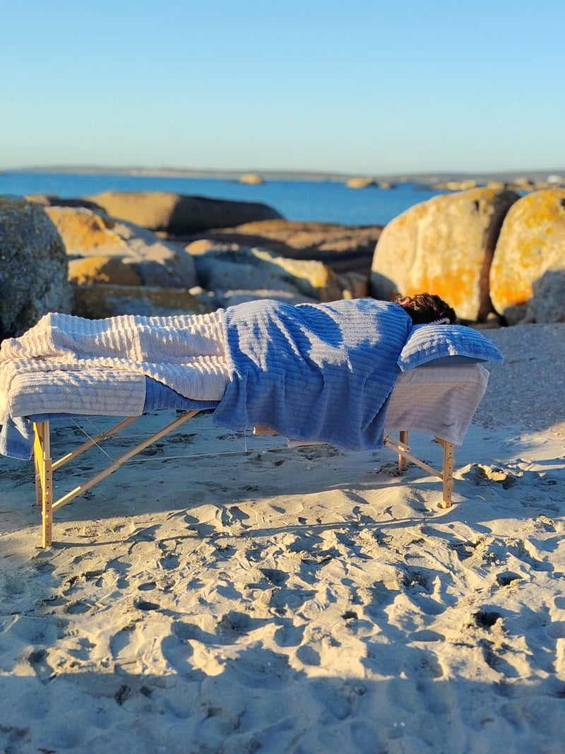 Relaxing beach massage experience on the West Coast with ocean scenery and spa treatment bed