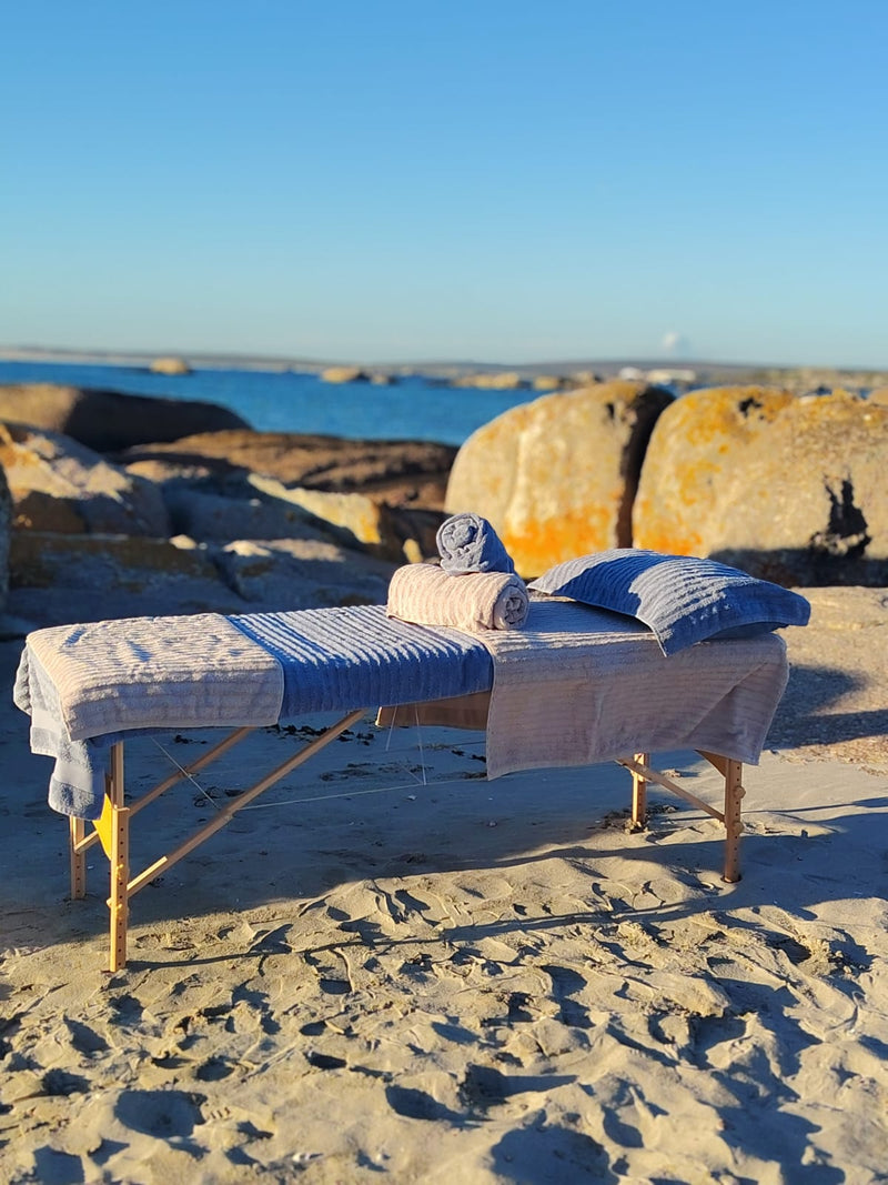 Mobile beach spa massage setup with soft towels and peaceful ocean backdrop in Paternoster