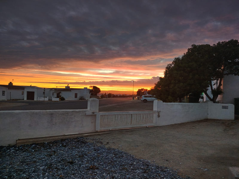 Paternoster sunset over coastal neighborhood with dramatic sky and peaceful evening atmosphere