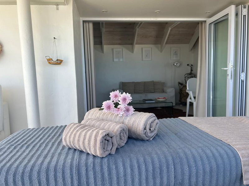 Luxury massage towels and flowers prepared for a relaxing Paternoster beachfront wellness treatment