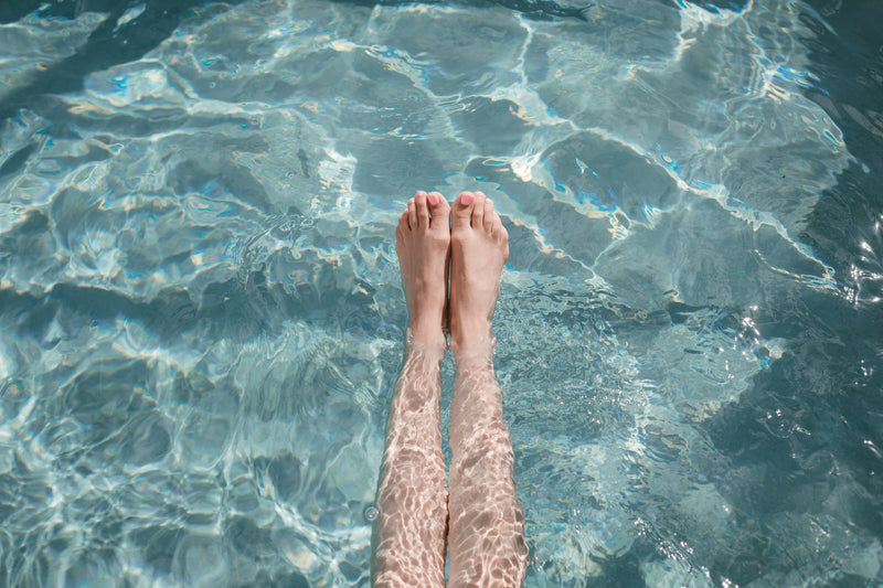 Relaxing poolside wellness experience with feet in crystal clear water at luxury spa retreat in Paternoster