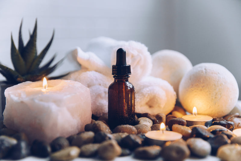 Luxury spa candles with rolled towels and essential oils creating a relaxing wellness atmosphere